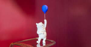 Winnie l’Ourson Small, sculpture design haut de gamme par Leblon Delienne, douce et joyeuse avec son ballon bleu. Disponible chez D-Style Interior