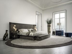 Capua lit design haut de gamme par Vittoria Frigerio avec tête de lit enveloppante à bandes verticales et inserts en cuir. Disponible chez D-Style Interior.