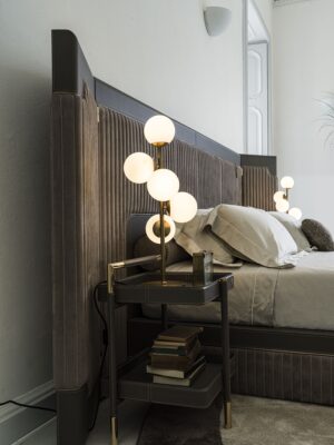 Capua lit design haut de gamme par Vittoria Frigerio avec tête de lit enveloppante à bandes verticales et inserts en cuir. Disponible chez D-Style Interior.