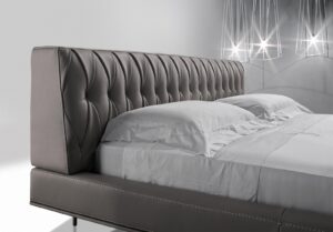 lit McQueen Night, un lit en cuir haut de gamme avec tête capitonnée artisanale et pieds métalliques élégants. Disponible chez D-Style Interior.